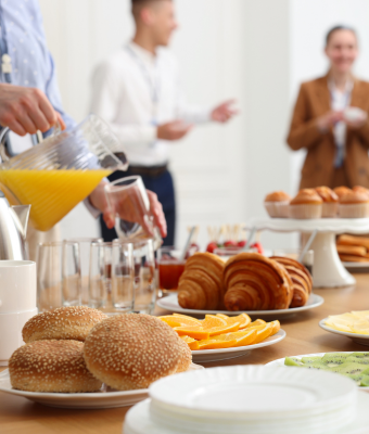 Group of employees in a meeting room consuming breakfast and lunch catering